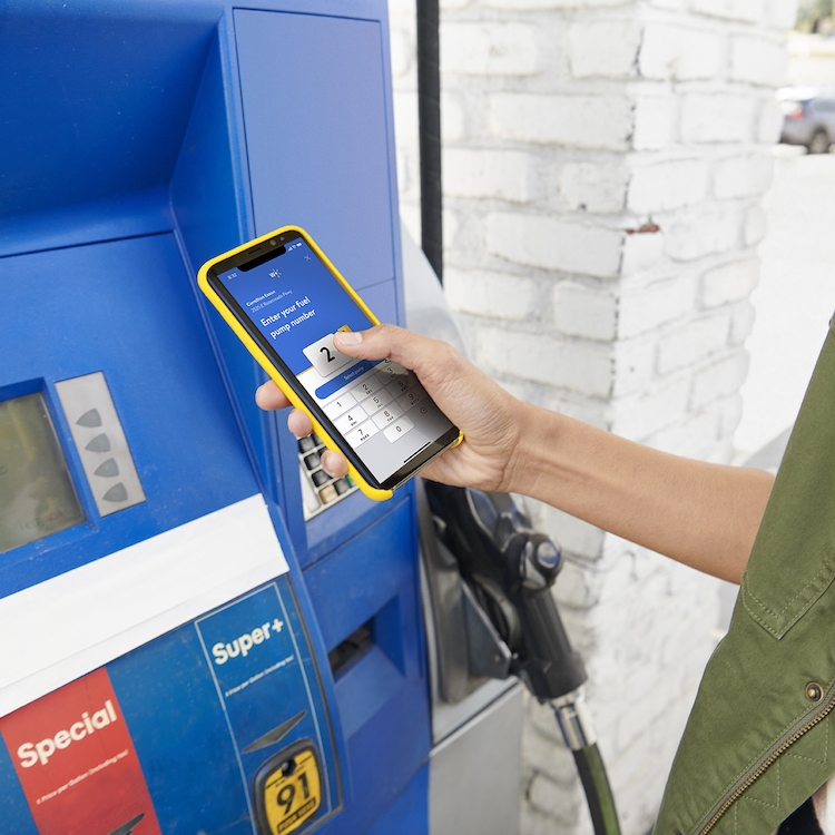 A customer prepares to pay at a gas pump using their mobile phone.
